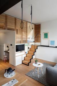 a living room with a staircase with a couch and a table at Zoku Amsterdam in Amsterdam