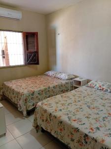 a room with two beds and two windows at BELL MAR CHALéS 05 in Luis Correia
