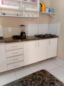 a kitchen with white cabinets and a counter top at BELL MAR CHALéS 05 in Luis Correia