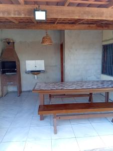 a patio with a wooden table and a stove at BELL MAR CHALéS 05 in Luis Correia