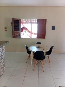 a table and chairs in a kitchen with a window at BELL MAR CHALéS 05 in Luis Correia