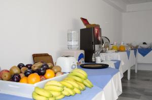 a table with a bunch of fruit on a blue table cloth at RK Beach Hotel in Kamari