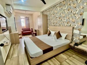 a hotel room with a bed and a chair at Deni Hotel in Patna