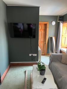 a living room with a couch and a tv on a wall at The Ormond Apartments in Dungarvan