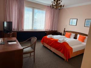a hotel room with a bed and a table and a desk at Hotel Bremer Kreuz in Achim