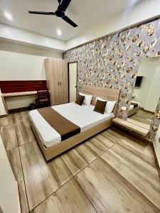 a bedroom with a bed and a wall at Deni Hotel in Patna