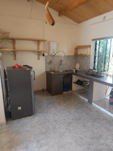 a kitchen with a refrigerator and a desk in a room at Harmal's Residency in Arambol