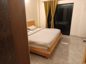 a bedroom with two beds and a window at Harmal's Residency in Arambol