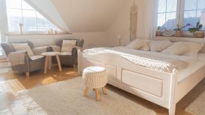 a bedroom with a white bed and a living room at Apartmány U Petry in Luhačovice