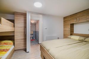 a bedroom with a large bed and wooden walls at Apartment Kamrca na Kopah in Šmartno pri Slovenj Gradcu