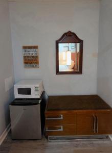 a small kitchen with a microwave and a mirror at Southington Motor Lodge in Southington