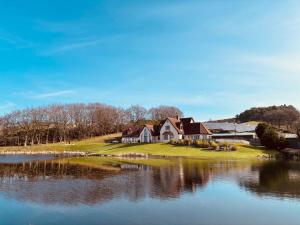 a house on a hill next to a lake at The Hoose at The Vu in Bathgate