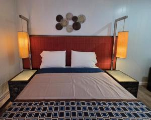 a bedroom with a bed with two lamps on it at Southington Motor Lodge in Southington +8 photos