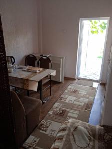a dining room with a table and chairs and an open door at Лазурит in Tamga