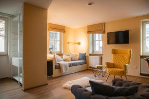 a living room with a couch and a chair at Posthotel Alexander Herrmann in Wirsberg