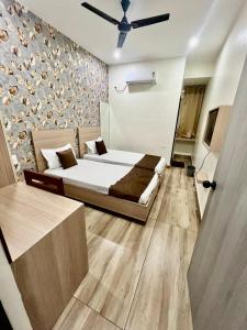 a bedroom with a bed and a wall at Deni Hotel in Patna +3 photos