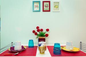 un tavolo con due piatti e un vaso con fiori di Viaggio a Napoli B&B a Napoli
