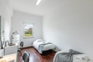 a white room with two beds and a mirror at HI Aveiro – Pousada de Juventude in Aveiro