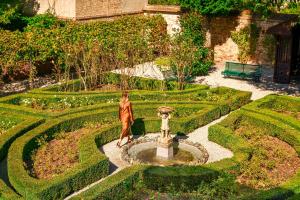 a woman standing next to a fountain in a garden at Danieli, Venezia, A Four Seasons Hotel in Venice