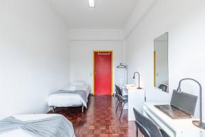a room with two beds and a red door at HI Aveiro – Pousada de Juventude in Aveiro