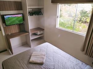 a bedroom with a bed and a tv and a window at Lacqua Diroma 12345 Caldas Novas in Caldas Novas +33 photos