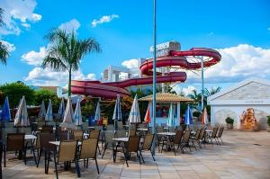 a group of tables and chairs with a water slide at Lacqua Diroma 12345 Caldas Novas in Caldas Novas
