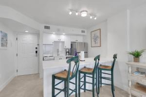 a kitchen with two green chairs at a counter at Lovers Key Resort 1107 in Fort Myers Beach