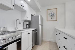 a white kitchen with a stove and a refrigerator at Lovers Key Resort 1107 in Fort Myers Beach