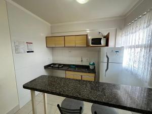 a small kitchen with a counter and a refrigerator at Lacqua Diroma 12345 Caldas Novas in Caldas Novas