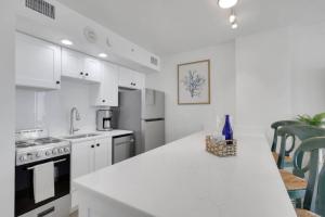 a kitchen with white cabinets and a white counter top at Lovers Key Resort 1107 in Fort Myers Beach +42 photos