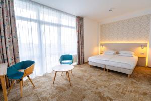 a bedroom with a bed and a table and chairs at Hotel Metropol in Warsaw +30 photos