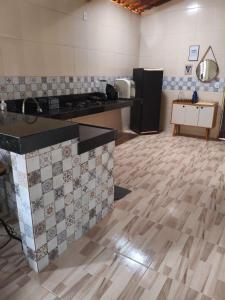 a kitchen with a tile floor and a counter top at Chalé Triunfo in Pacoti