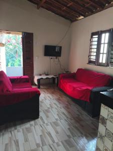 a room with a couch and a bed and a tv at Chalé Triunfo in Pacoti