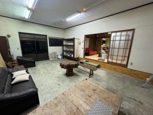 a living room with a couch and a table at ゲストハウス虎のいえ in Sukumo