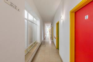 a hallway with a red and yellow door in a building at HI Aveiro – Pousada de Juventude in Aveiro +24 photos