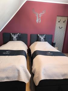 two beds in a room with a red wall at Ferienwohnung Kampić Turmblick in Rottweil