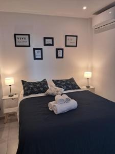 a bedroom with a black bed with towels on it at Monoambiente zona UNNE in Resistencia