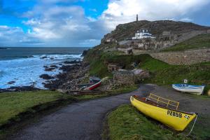 a yellow boat sitting on the side of a road next to the ocean at The Tremont in Penzance +23 photos