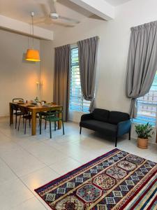 a living room with a table and a dining room at A home with private pool, KebunStorey in Tangga Batu