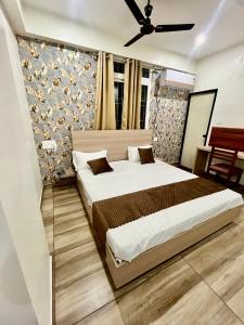 a bedroom with a large bed and a wall at Deni Hotel in Patna