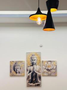 four pictures of buddha paintings on a wall at Warm Nest in Dehradun