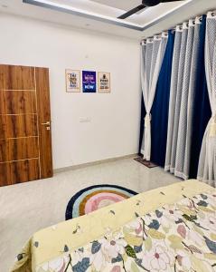 a bedroom with a bed and a door with curtains at Warm Nest in Dehradun +34 photos