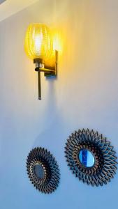 two mirrors on a wall with a light and a lamp at Warm Nest in Dehradun