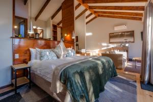 a bedroom with a large bed with a wooden headboard at Elephant Hide of Knysna Guest Lodge in Knysna +125 photos