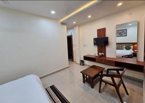 a room with a couch and a tv and a bed at Hotel Sunrise in Damoh