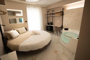 a bedroom with a bed and a bathroom with a tub at Elysium suites & Spa in Barletta