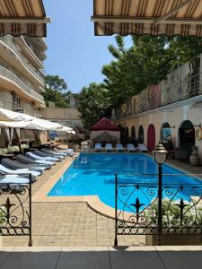 ein Schwimmbad mit Liegestühlen neben einem Gebäude in der Unterkunft Hotel Otrada in Odessa
