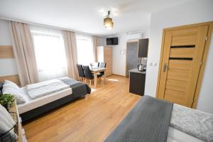 a hotel room with two beds and a dining room at Apartamenty Tilia Laskowa - Zator in Laskowa