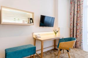 a room with a desk and a tv and a chair at Hotel Metropol in Warsaw