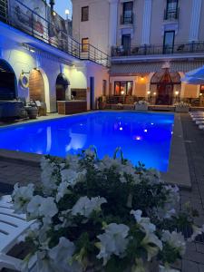 ein Teich mit weißen Blumen vor einem Gebäude in der Unterkunft Hotel Otrada in Odessa + 117 Fotos